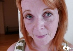 Red-haired older lady teasing with her boobies